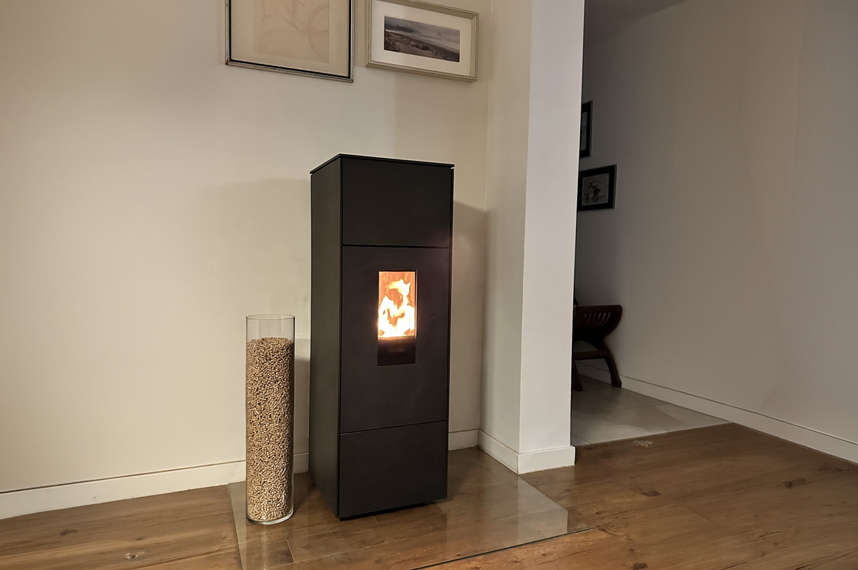 Poêle à granulés moderne installé dans une habitation avec réservoir de pellets à proximité dans le 64 (Pyrénées-Atlantiques).