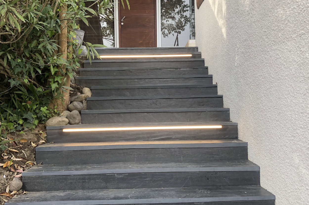Éclairage LED intégré aux marches d’un escalier extérieur pour sécuriser l’accès à une habitation et baliser le cheminement de nuit dans le 64 (Pyrénées-Atlantiques).