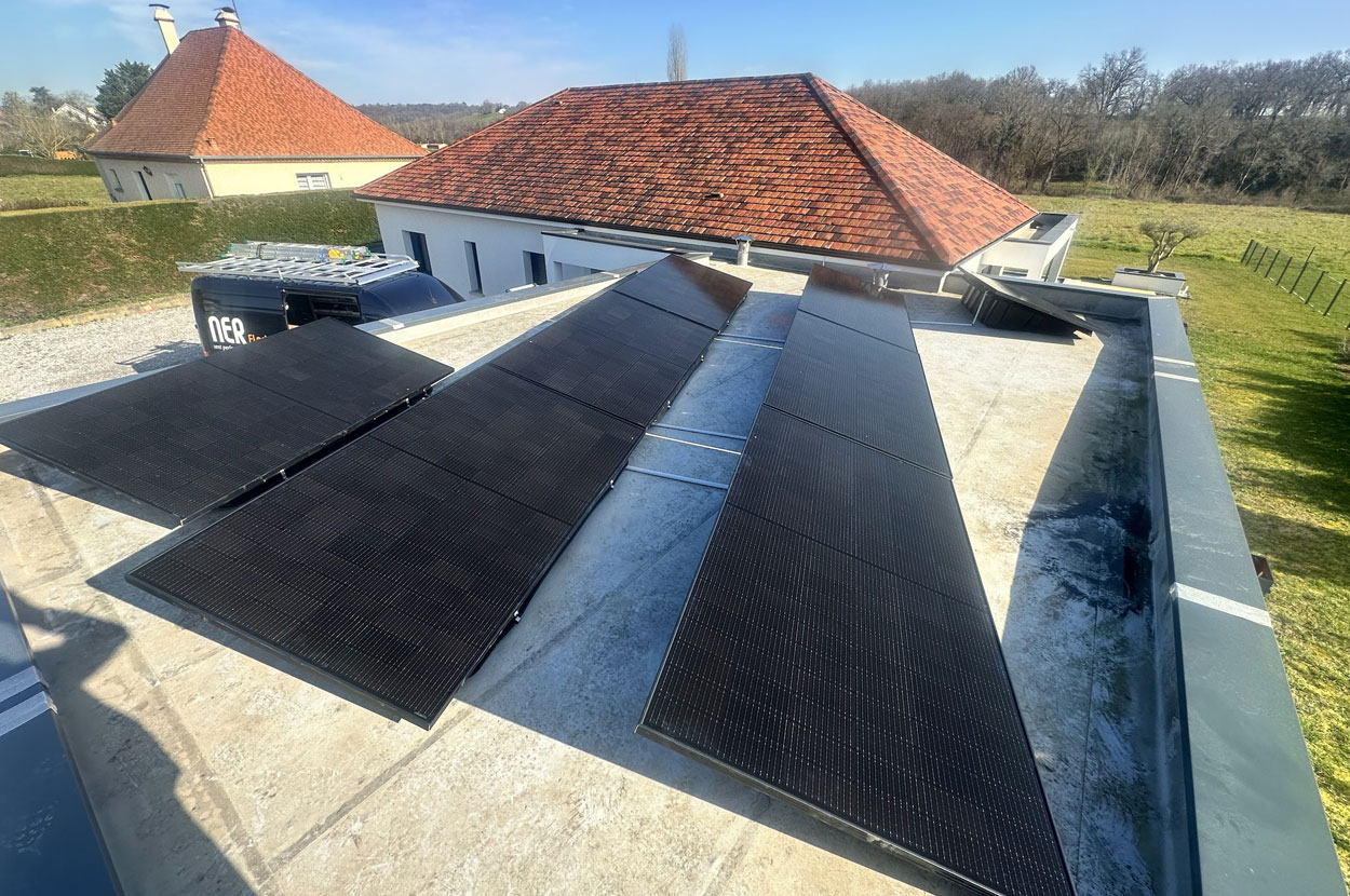 Panneaux photovoltaïques installés sur une toiture-terrasse résidentielle avec structure inclinée pour optimiser l’exposition au soleil dans le 64 (Pyrénées-Atlantiques).
