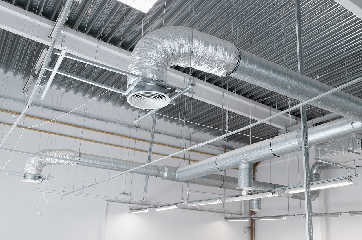 Réseau de gaines de ventilation installé au plafond d’un bâtiment professionnel pour le renouvellement de l’air intérieur dans le 64 (Pyrénées-Atlantiques).